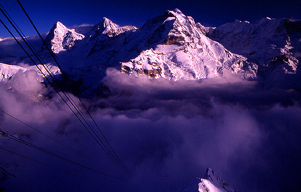 The view from the Shilthorn (2971m) down into the cloud towards the cable station at Birg (2676m).
<br>
Eiger (3970m), M�nch (4099m) and Jungfrau (4158m) in the background
<br>
Photo: Robert Downie - January 2002 (EOS 300) 