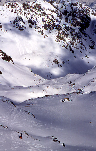An unknown boarder free riding across a large unmarked valley - Valbella
<br>
Notice the twin avalanche scars in the top left of the picture and how small the big 6 seater lift looks in the background 
<br>
Photo: Robert Downie - February 2002 (EOS 300) 